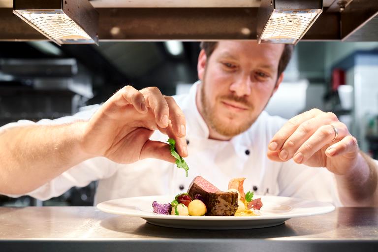 Chef at Hotel Waldschloesschen prepares gourmet dinner plate